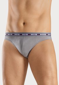 Graue Baumwollunterhose mit einer enganliegenden Passform. Verfügt über einen weiß-roten gestreiften Bund mit "HIS"-Markierung. Glatte Textur, niedriger Schnitt.