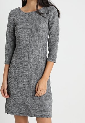 Robe en tricot gris avec des manches trois-quarts, présentant un panneau côtelé vertical d'un côté et une texture lisse de l'autre.