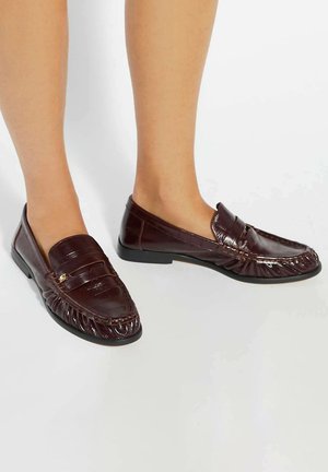 Dark brown leather loafers with a rounded toe, decorative stitching, and a flat heel. Features a pleated design and gold hardware accent.