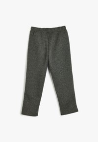 Pantalones de chándal grises con una cinturilla elástica, textura suave, diseño de pierna recta y bolsillos a ambos lados.
