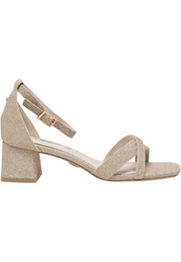 Beigi sädelevad plokknina kettiga sandaalid ristuvate rihmadega. Omadused: reguleeritav ankle strap ja sile sisepind. Tekstureeritud pealis.