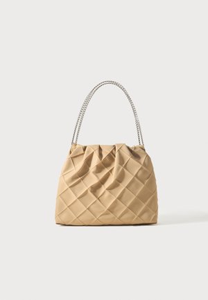 Beige gewatteerde handtas met zachte textuur en zilveren kettingriem, geplooide details nabij de bovenkant, weergegeven op een eenvoudige lichte achtergrond.