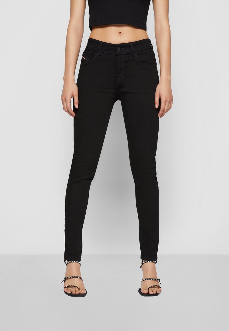 Černé skinny džíny s přiléhavým střihem, které mají pět kapes a jemné švy. Vybavené se strapcovými černými sandály.
