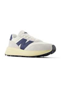 Sneakers with a cream mesh upper, navy leather accents, and grey suede detail. Light cream midsole and black textured outsole.