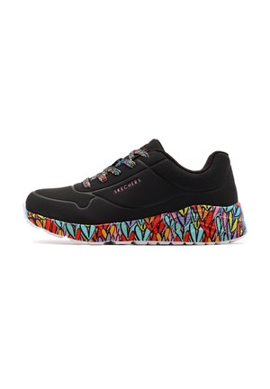 Chaussures de sport noires avec un dessus texturé, présentant des motifs de cœurs colorés sur la semelle et des lacets multicolores. Nom de la marque sur le côté.