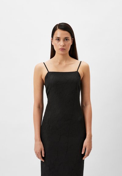 Black dress with a textured finish, square neckline, and thin straps, fitted silhouette, resting at the ankles against a plain background.