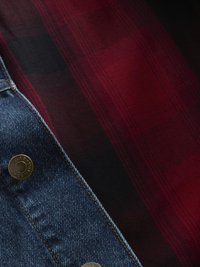 Denimjakke med knapp i messing og blå vask; lagdelt med et rødt og svart rutete stoff med fiskebeinsmønster.