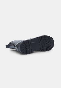 Černá waterproof bota s hladkým povrchem, vybavená robustní gumovou podrážkou a hlubokým vzorem pro dobrou přilnavost. Součástí je zadní poutko.