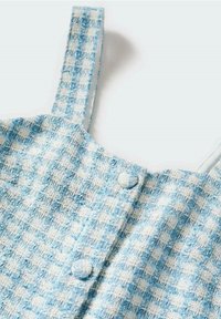 Modrá a bílá kostkovaná šaty s ramínky, vyrobené z texturované látky a se světlými knoflíky vpředu pro zapínání.