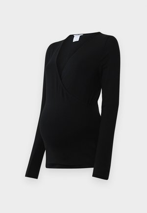 Črna majica z dolgimi rokavi je zasnovana za nosečnice, ima ovit stil in raztegljiv material za udobje nad rastočim trebuhom.