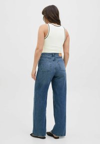 Højtaljede bredbenede jeans i mørkeblåt denim, med et klassisk fem-pockets design og en læderpatch på bagdelen af taljen.