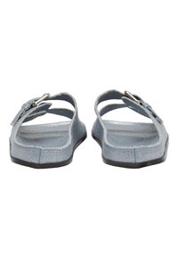 Helle blaue Stoffsandalen mit offener Ferse, zwei oberen Riemen und einem silbernen Schnallendetail. Flache Sohle mit strukturierter Oberfläche.
