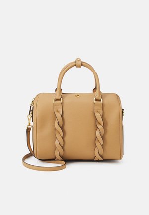 Sac à main en cuir texturé couleur tan avec des bretelles avant torsadées, des ferrures dorées, deux poignées et une bandoulière amovible sur fond blanc.