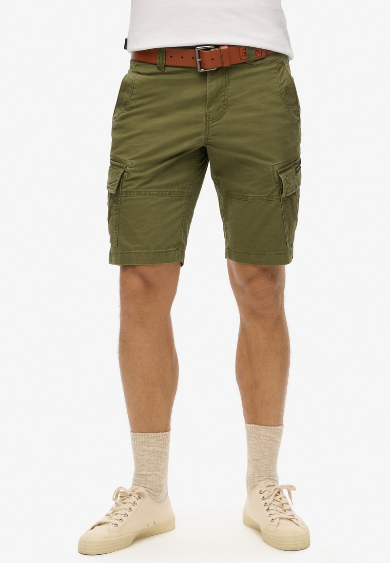 Pantaloni cargo verde oliva con più tasche, un tessuto testurizzato e una vestibilità dritta, abbinati a una cintura in pelle marrone.