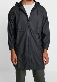 Czarna lekka kurtka przeciwdeszczowa z kapturem, elastycznymi mankietami, pełnym zamkiem błyskawicznym i dwoma przednimi kieszeniami, wykonana z gładkiego, wodoodpornego materiału.