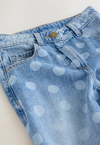 Blugi din denim bleu deschis cu un model cu buline, prevăzuți cu buzunar frontal, închidere cu nasturi și detalii contrastante de cusături.