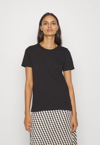 Zwarte katoen T-shirt met korte mouwen en een klassieke ronde halslijn, gecombineerd met een met patroonenrokken met diamantvormen in neutrale tinten.