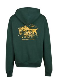 Grøn hættebluse med en blød tekstur. Har et gult grafisk print af en hest og hunde på ryggen, samt ribbede manchetter og kant.