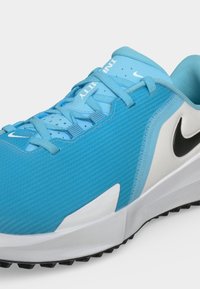Μπλε και λευκό παπούτσι για τρέξιμο Nike Infinity με μαύρο λογότυπο Swoosh, υφασμένο επάνω μέρος και ανοιχτό μπλε κορδόνια σε λευκή σόλα.