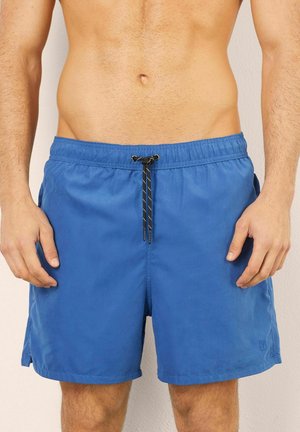 Shorts de bain bleus en tissu léger avec une taille élastique et un cordon de serrage ajustable. Comprend des fentes latérales pour plus de facilité de mouvement.