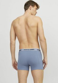 Blauwe heren boxershorts met een zwart-wit logo tailleband, met een nauwsluitende pasvorm en een gladde structuur. Aanzicht van achter zonder aanvullende patronen.