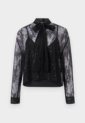 Melnā caurspīdīgā blūze ar garām piedurknēm, mežģīņu pārklājumu, sekla akcentiem un kakla saitīti. Iezīmē slāņveida dizainu un teksturētu audumu.