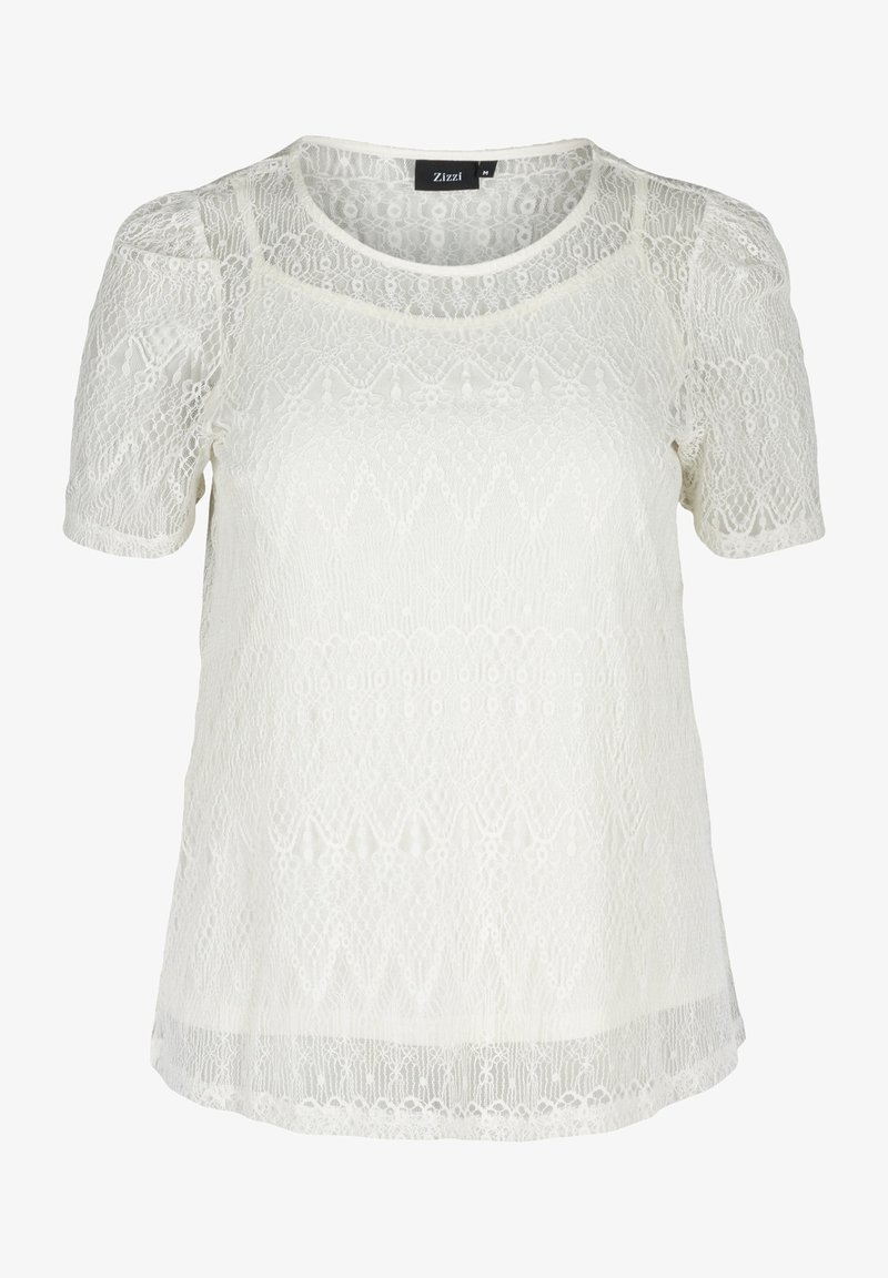 Bílý krajkový top s krátkými rukávy, který má jemné vzory, kulatý výstřih a mírně průsvitnou texturu. Viditelný štítek značky.