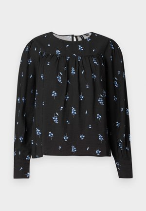 Svart langermet bluse med blå blomstermønster, rund halslinning, rynkede detaljer og knappelukking bak. Myk tekstur.