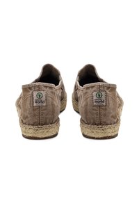 Zapatos estilo espadrille con un upper de lona de color marrón claro, detalles de cuerda de yute en la suela y una pequeña etiqueta con la inscripción "natural world" en el talón.