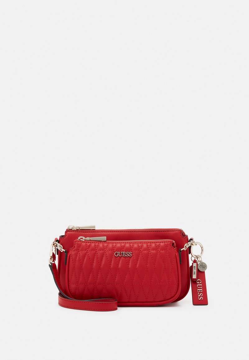 Bolso bandolera acolchado rojo con textura suave, compartimentos dobles con cremallera y herrajes plateados brillantes. Cuenta con una correa desmontable y etiqueta con el logo.