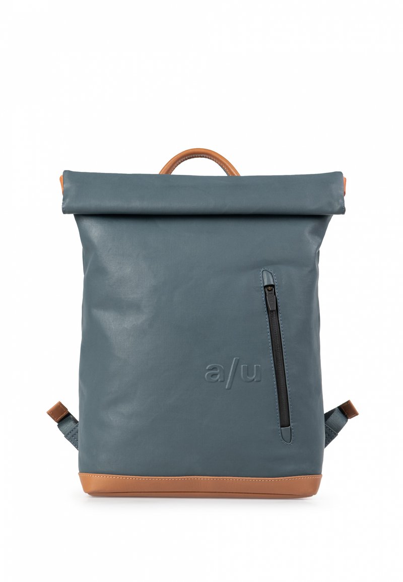 Rugzak in donkerblauw waterdicht materiaal met een rol-top sluiting, tan leren accenten, een zijvak met rits en verstelbare schouderbanden.