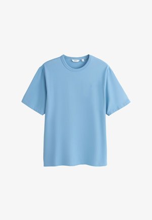 T-shirt bleu clair à manches courtes et col rond avec un petit logo brodé sur le côté gauche de la poitrine, présenté à plat sur un fond blanc.