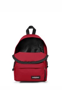 Mochila de tela roja con cierre de solapa, forro negro y bolsillo frontal con cremallera. Incluye un asa superior y correas de hombro ajustables.