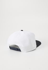 Beli bejzbolski kap s črnim vizirjem, nastavljivim snapback zapiranjem in gladkim tkaninskim vzorcem. Ima kontrastni črni gumb na vrhu.