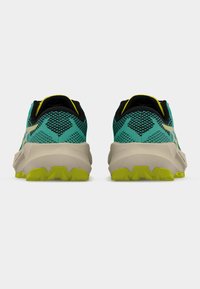 Παπούτσια για μονοπάτια με επάνω μέρος από τυρκουάζ διαπνέον δίχτυ, μαύρη επένδυση, μπεζ ενδιάμεση σόλα και φωτεινή κίτρινη εξωτερική σόλα με υφή για καλύτερη πρόσφυση.