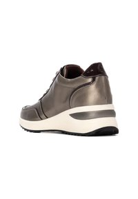 Sneaker in bronzo metallico con finitura testurizzata, allacciatura frontale e suola bianca spessa. Presenta dettagli in marrone scuro sul tallone.