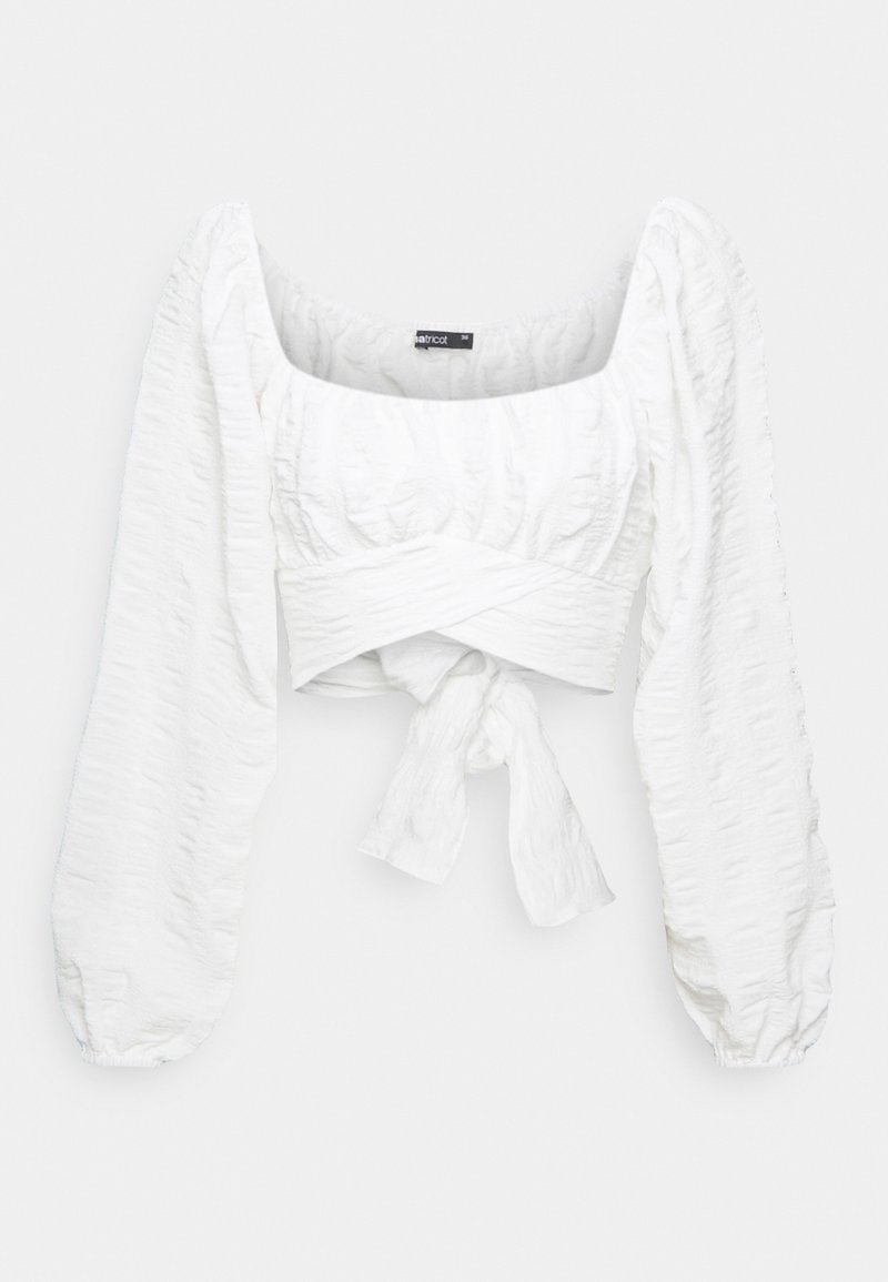 Top bianco corto con maniche lunghe e puff. Presenta un tessuto testurizzato con un design avvolgente e un nodo davanti. Scollatura quadrata.