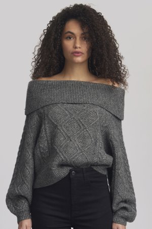 Grauer, schulterfreier Pullover mit strukturiertem Kabelstrick und geripptem Ausschnitt, kombiniert mit schwarz-fitzenden Hosen. Weiches, voluminöses Strickdesign.