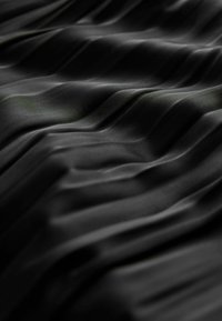 Black fabric with a smooth, slightly shiny texture, featuring prominent horizontal pleats that create a wavy pattern across the surface.