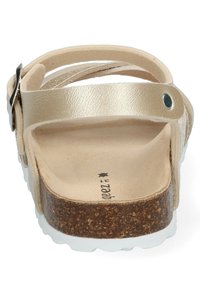 Sandalias de cuero dorado con correa ajustable en el tobillo, plantilla de corcho y suela blanca; textura suave con detalles de diseño mínimos.