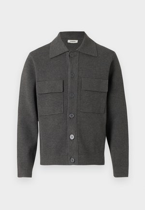 Donkergrijze jas met knopen, een puntige kraag en twee grote klepzakken op de borst, gemaakt van gebreide stof.