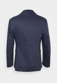 Blazer blu navy con vestibilità su misura, single vent, rever a punta, maniche lunghe e polsini con tre bottoni. Tessuto dalla superficie liscia.
