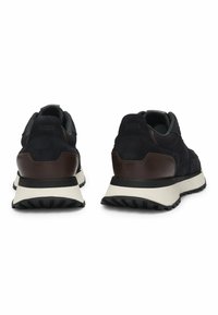 Sneaker da uomo in suede blu navy con dettagli in pelle marrone, dotati di una suola intermedia bianca e una suola esterna nera testurizzata. Design traspirante con stile a taglio basso.