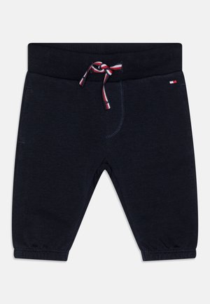 Pantalones cortos de color azul marino con cintura elástica, cordón con rayas rojas y blancas, y puños elásticos en el dobladillo.