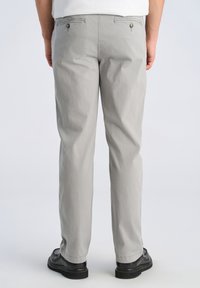 Graue Baumwollhose mit geradem Schnitt, ausgestattet mit zwei Gesäßtaschen mit Knopfverschluss und einer leicht zerknitterten Textur.