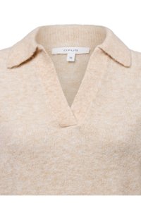 Pull en tricot beige avec un col en V et un col, présentant une texture douce et un motif mélange subtil. L'étiquette indique la marque "OPUS", taille 36.