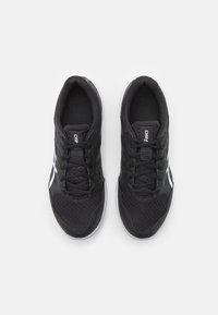 Black athletic shoes with a mesh upper, featuring a textured surface, round toe, traditional lacing, and white brand logo accents.