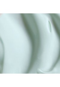 Crème vert clair avec une texture lisse et brillante et des motifs ondulés subtils à la surface. Pas de particules ou de débris visibles.