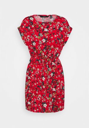 Czerwona sukienka z krótkim rękawem, z taliowaniem i wzorem kwiatowym w białe, żółte i zielone kwiaty na jednolitym tle.