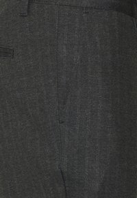 Szare, dopasowane spodnie wykonane z teksturowanej tkaniny, z delikatnymi pionowymi paskami, bocznymi kieszeniami i eleganckim, dopasowanym krojem.